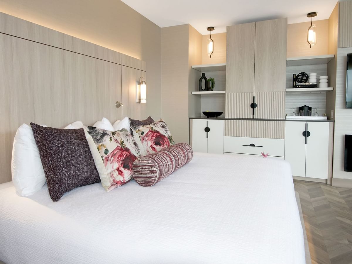 Hotel guestroom with king bed, TV, fireplace, and coffee maker