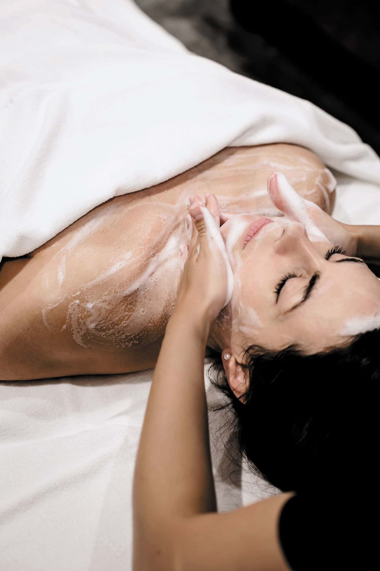 Lady having face & body scrub at Domaine de Manville