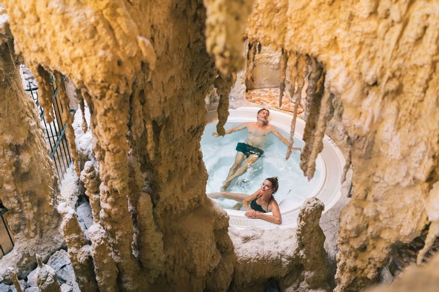 A couple enjoying a cave bath at a spa in Liebes Rot Flueh