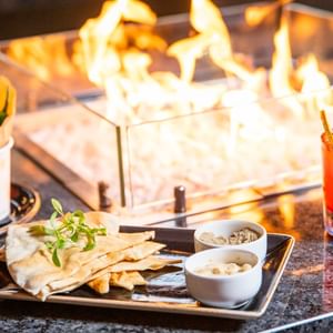 Naan bread & cocktail served by a fire at Guoman Hotels