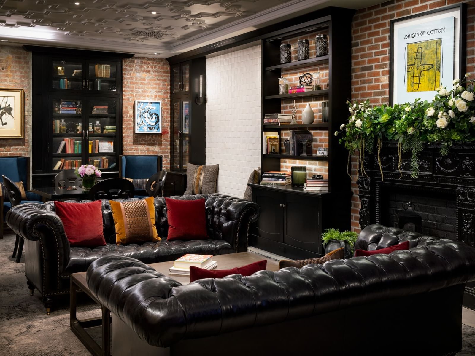 Library with leather couches, bookshelves, fireplace, and art at ArtHouse Hotel New York City.
