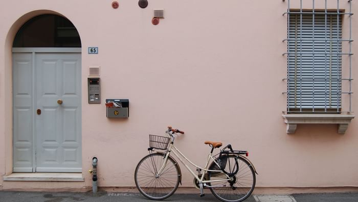 Bicycle parked by a pink color building near Originals Hotels