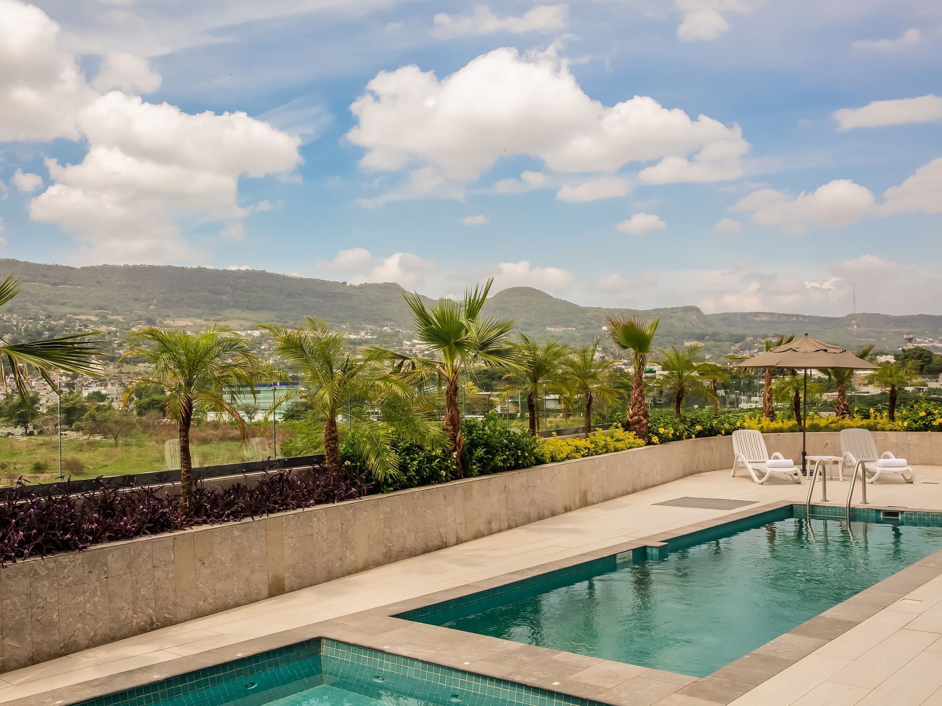 Outdoor swimming pool with pool chairs at Fiesta Inn Hotels