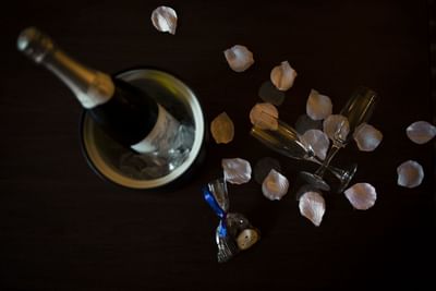 Champagne in an ice bucket with two glasses and petals