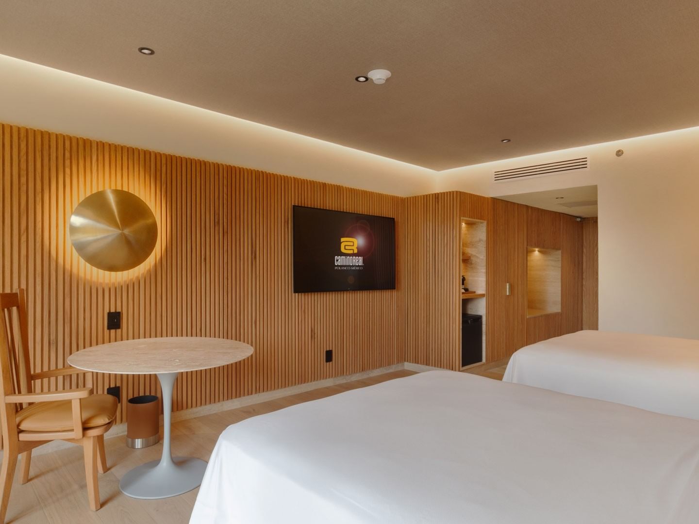 2 Double Superior Camino Real Club with wooden walls, a white round table, and two twin beds at Camino Real Polanco Mexico