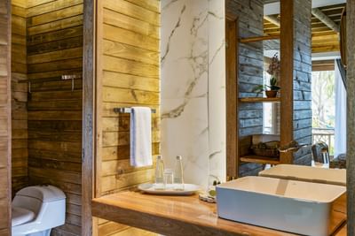 Vanity area with wash basin, mirror, and bath robes at Hotel Isla Del Encanto