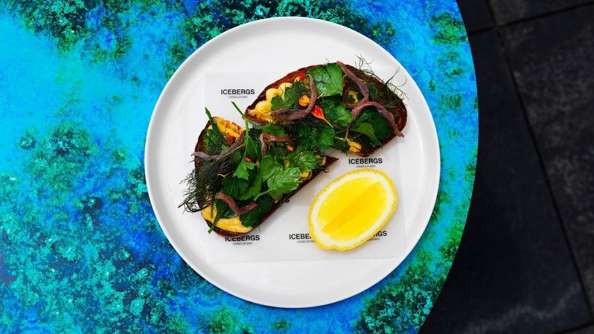 Open-faced sandwich on a plate with lemon slice served in Icebergs Harbour Bar at Crown Hotels