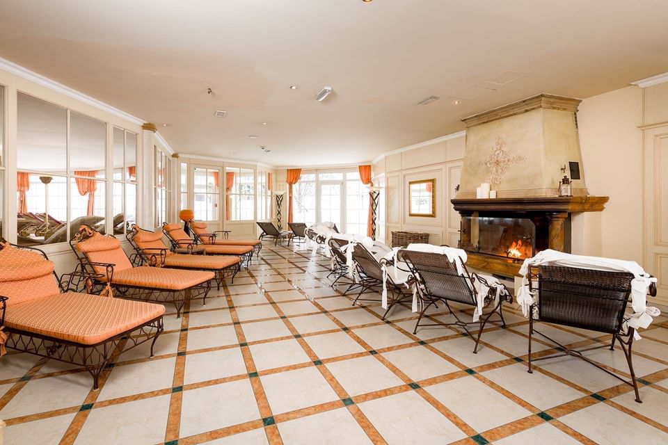 Lounge chairs in a room with a fireplace at a spa in Liebes Rot