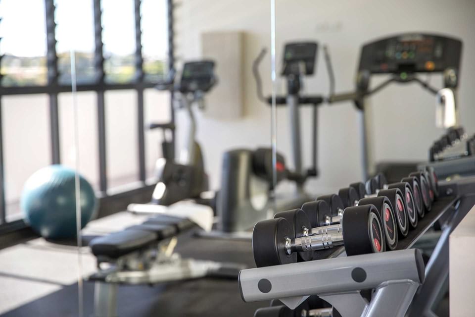 Fitness room with cardio & free-weight equipment and family-friendly amenities at Alcyone Hotel Residences