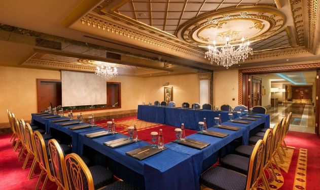 Titanic Deluxe Golf Belek'teki Convention Center’da U şeklinde masa düzeni ve projeksiyon perdesi.