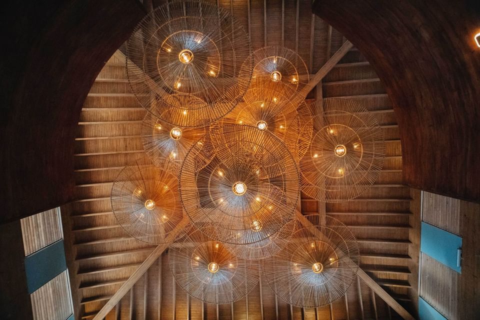 Ceiling view of a wooden event room with spherical light fixtures at Indura Beach & Golf Resort