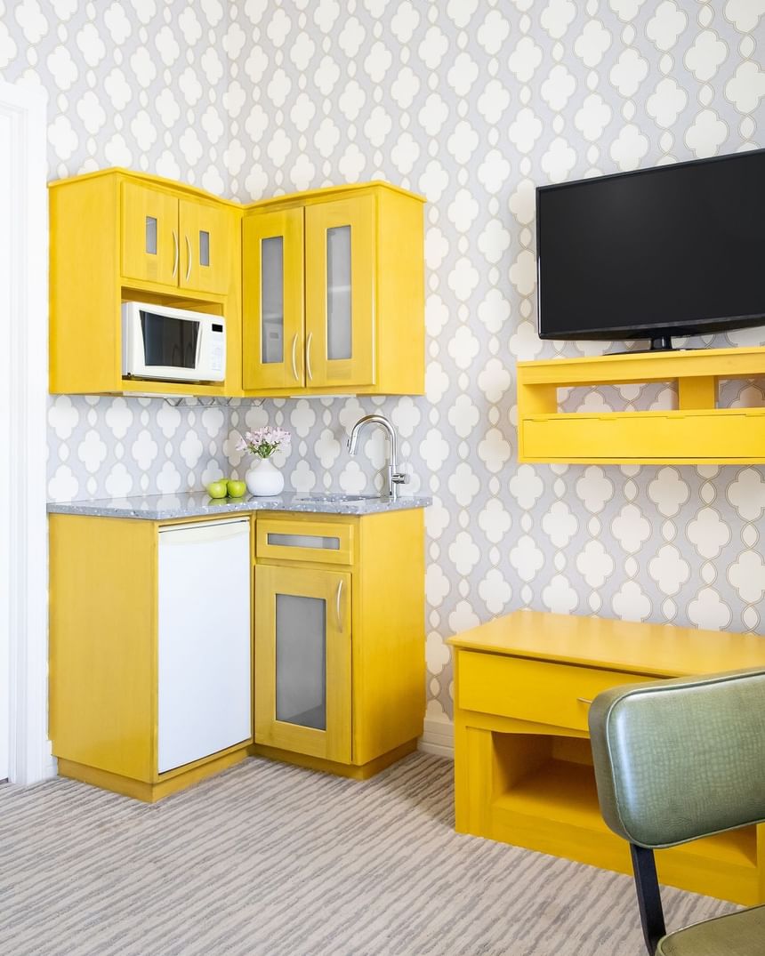 a bright yellow kitchenette with decorative wall paper and a wal