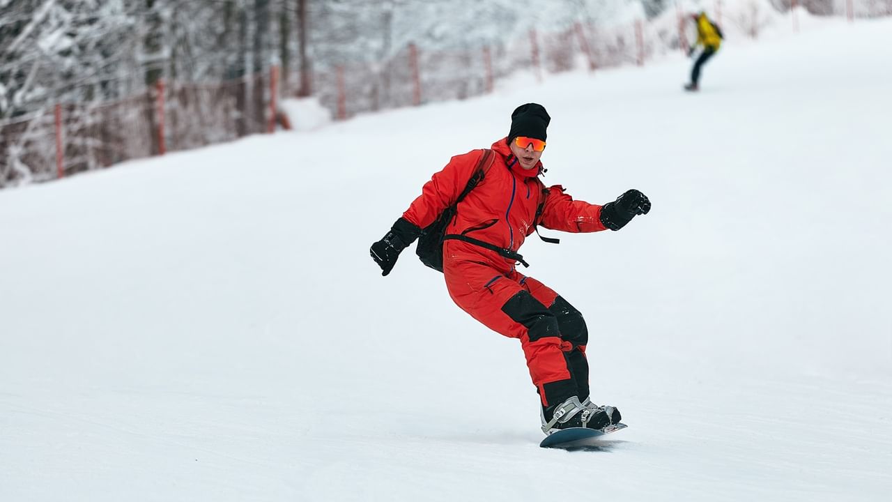 Snowboarder glides down a snowy slope.