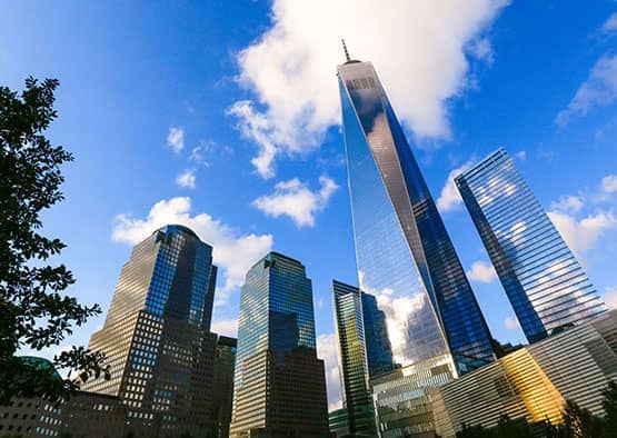 A cityscape with skyscrapers under a blue sky with clouds