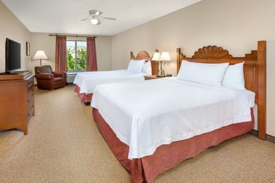 Bright Two Queen Beds One Bedroom Suite at Hilton Santa Fe Buffalo Thunder featuring a TV and comfy armchair