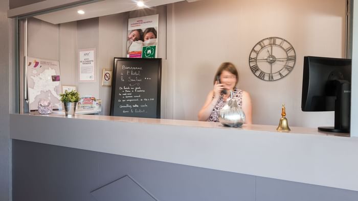 A receptionist at the reception desk in Hotel La Saulaie