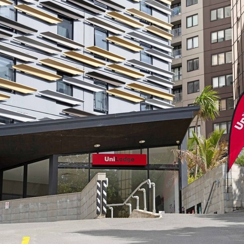 Modern hotel entrance with UniLodge sign and red banner at UniLodge Auckland City.