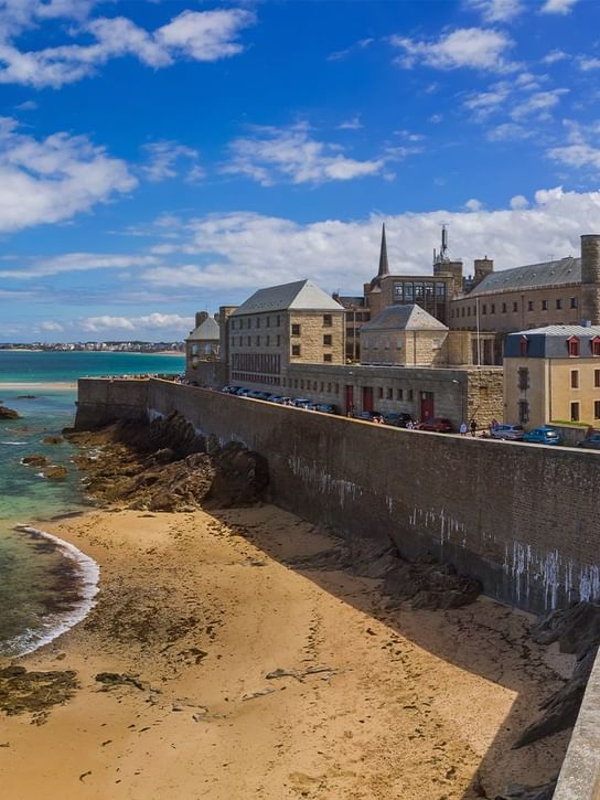 Exterior of the National Fort with beach and turquoise waters in Saint-Malo near Oceania Hotels