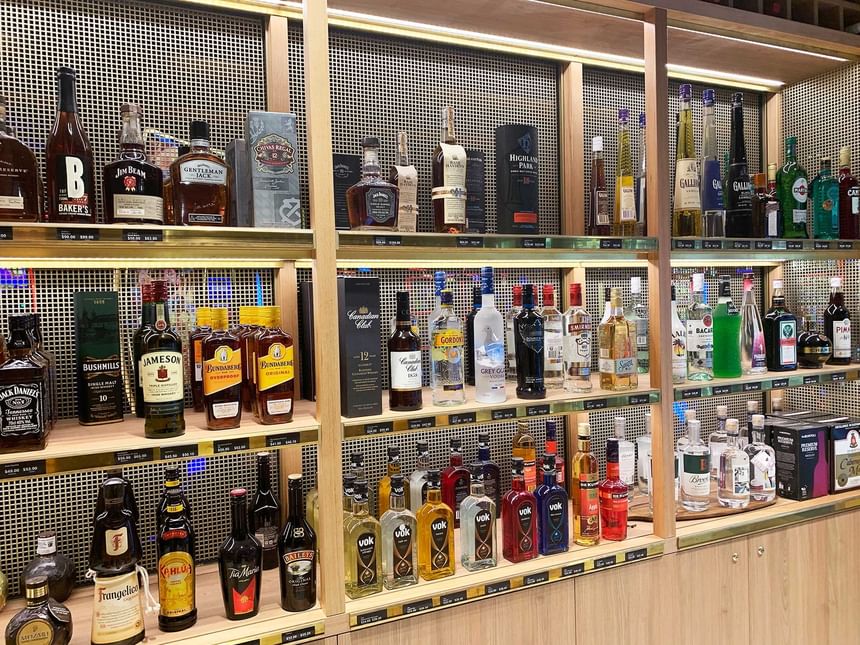 A shelf stocked with various brands of liquor bottles at Encore by Mingara