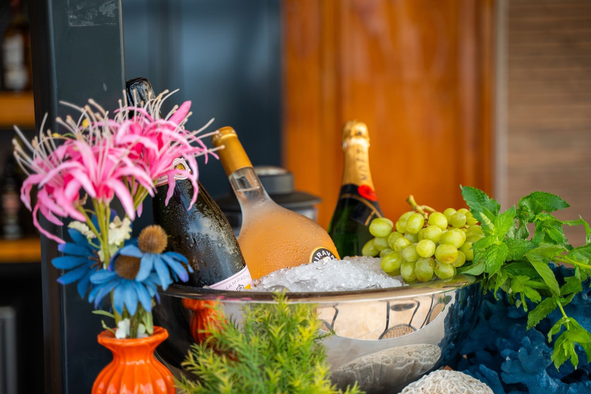 Stijlvolle ijsemmer met drie flessen champagne, bloemen, druiven en munt in de Pool Bar bij Golden Rock Resort