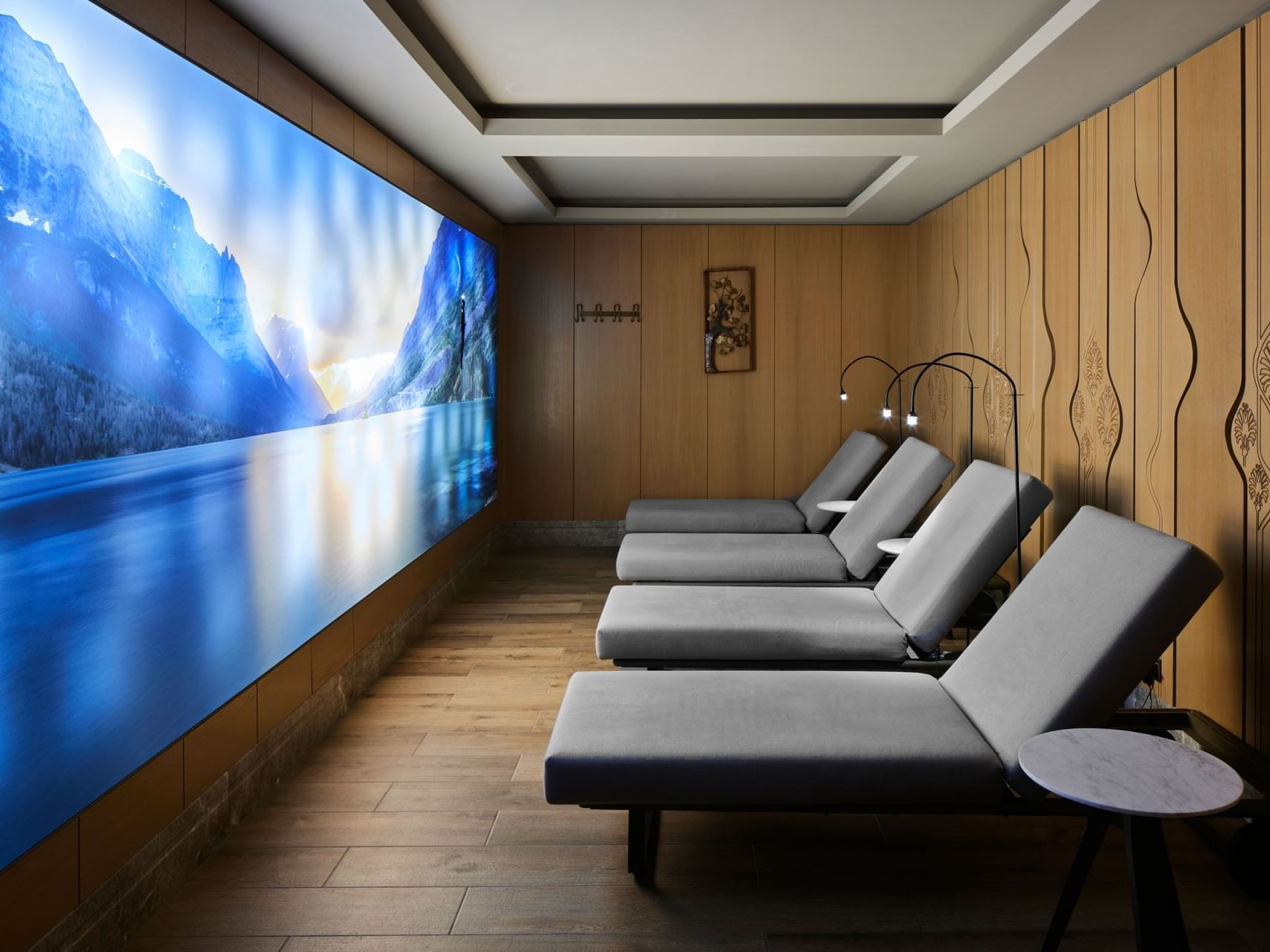 Entspannungsraum mit Liegen und großem Wandbild einer Berglandschaft – Titanic Chaussee Berlin.
