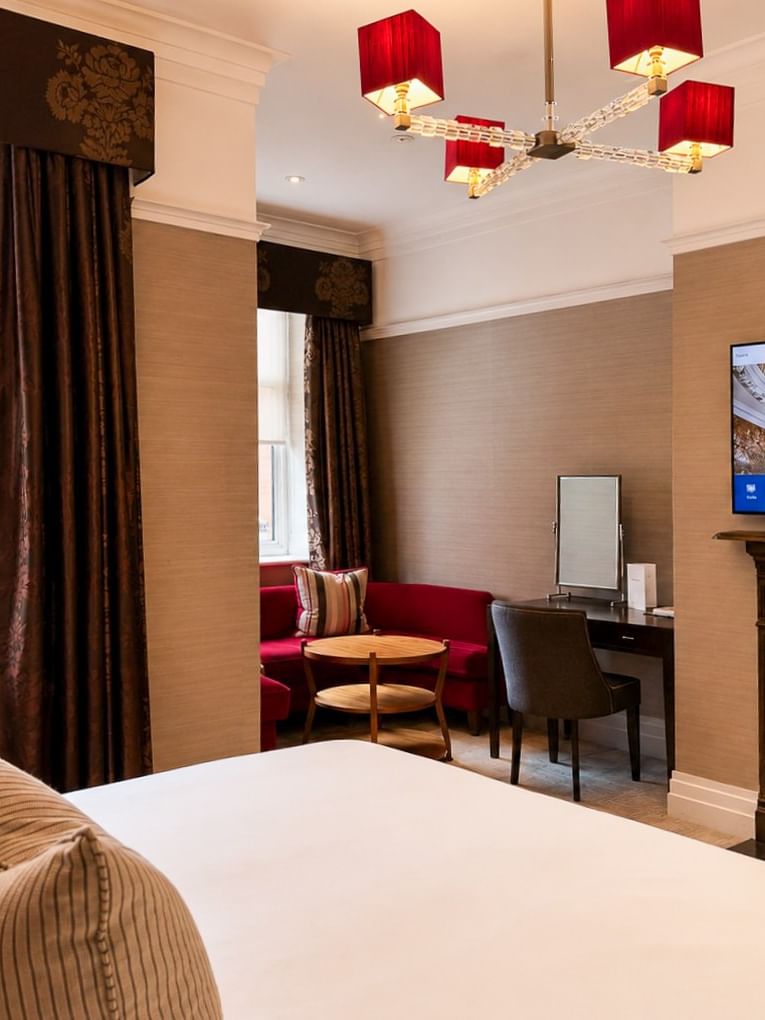 Deluxe King room at The Capital Hotel, Apartments & Townhouse in London with fireplace and TV.