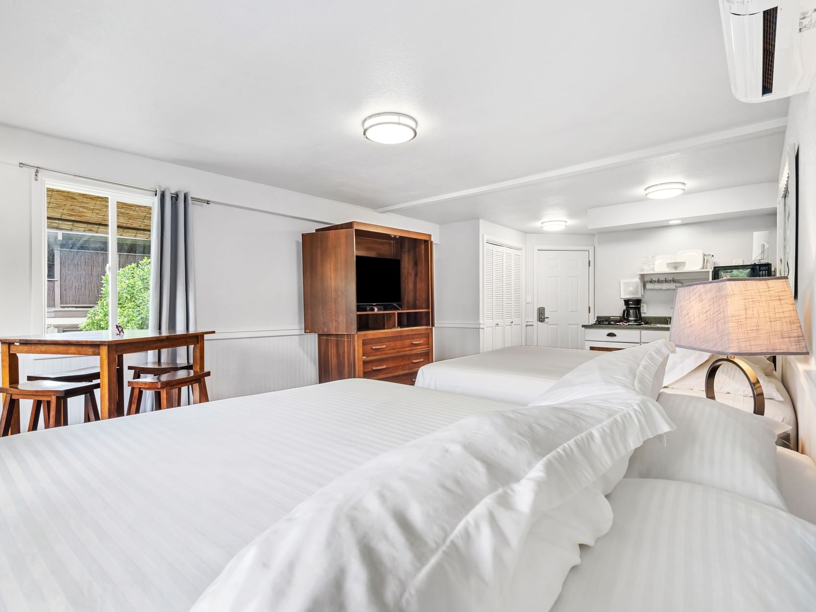 Two comfy beds & wooden furniture in Studio Suite View at Paradise Bay Resort