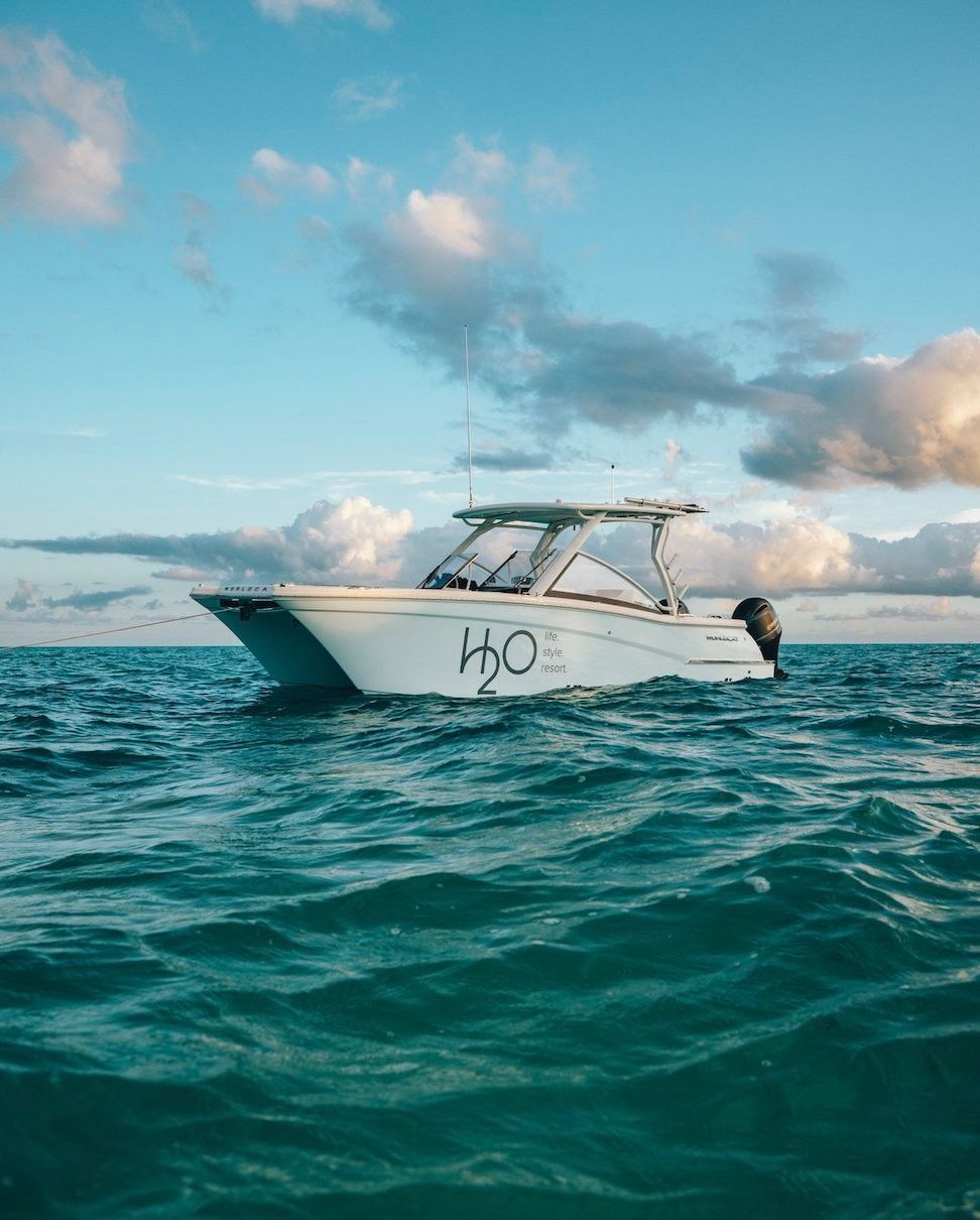 H2O life.style.resort branded boat at anchor on the Caicos Banks at golden hour