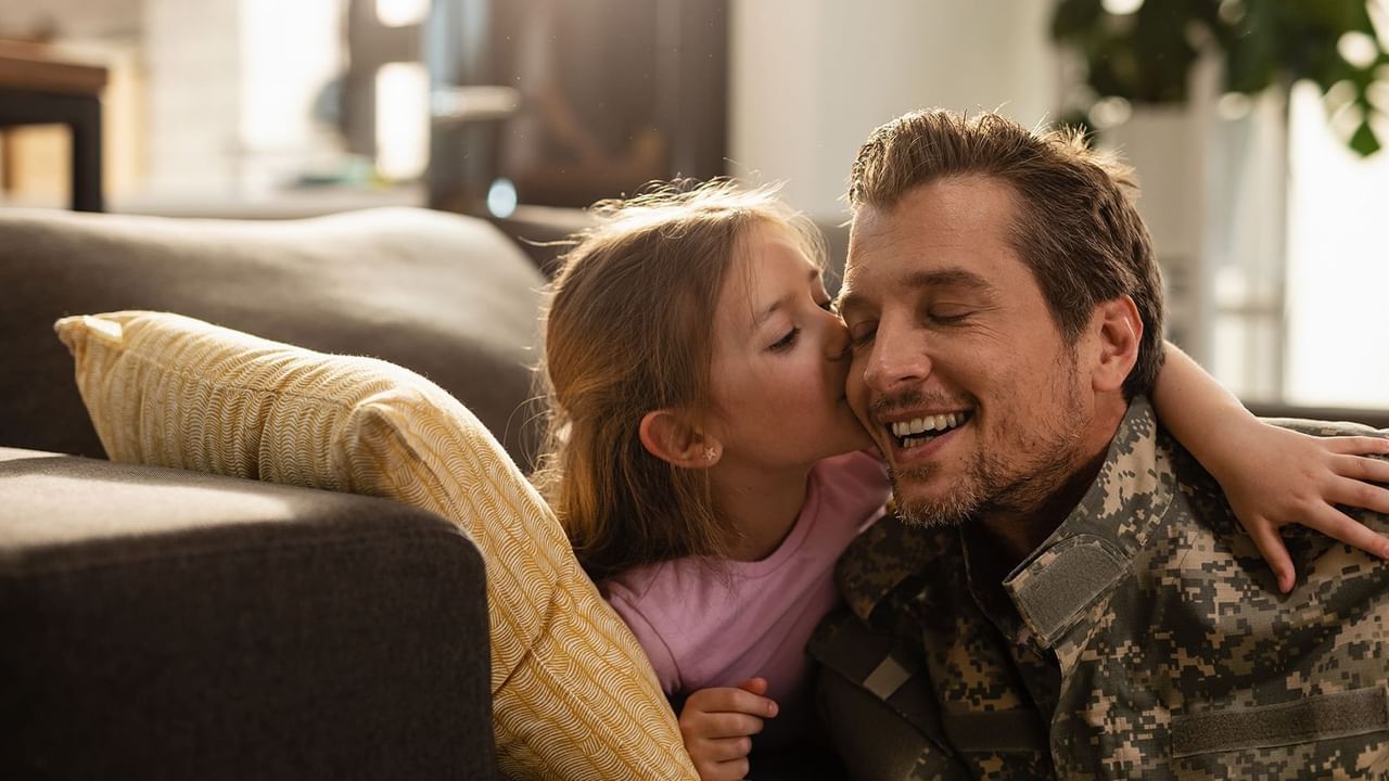 A daughter kissing her military dad