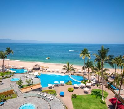 Foto de las instalaciones exteriores del hotel Sunset Plaza Beach Resort, con bañera de hisdromasaje, tumbonas, piscinas y vistas a la playa en Puerto Vallarta
