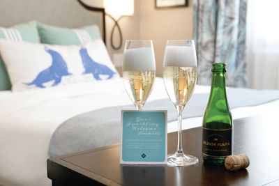 Two Champagne glasses served by the bed in Accessible King Room at Hotel Atwater
