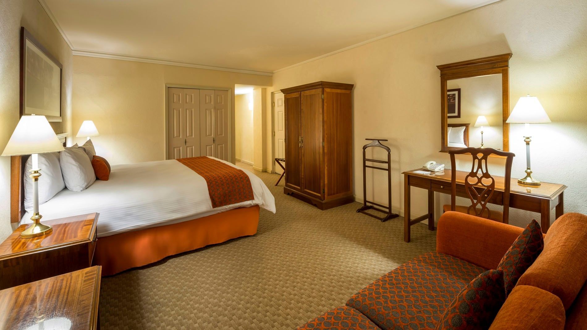 King Camino Real Club with a wooden armoire, work desk, and patterned rug at Camino Real Puebla Angelopolis
