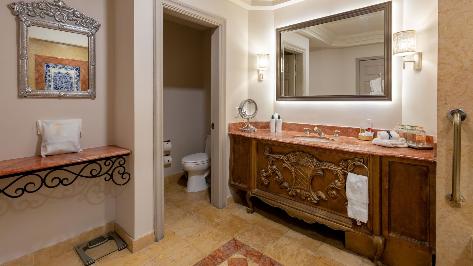 Baño elegante con tocador de madera tallada y cubierta de mármol en Quinta Real Monterrey, San Pedro Garza García