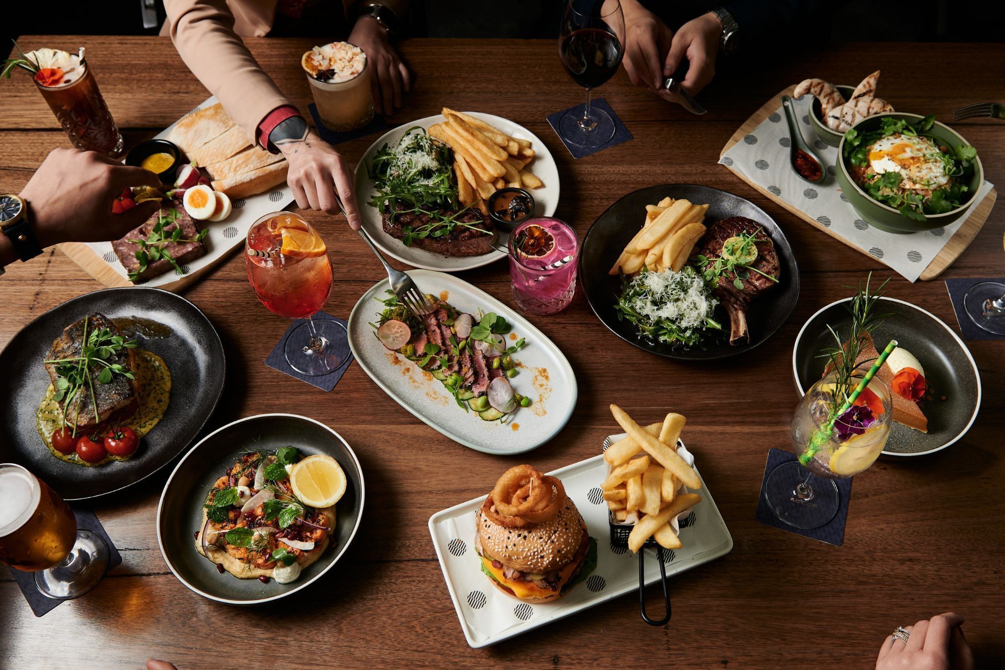 A dining table full of various meals in Mortimer's Lounge at Pullman Albert Park