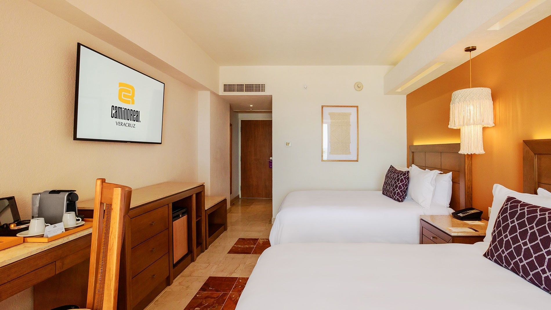 2 Double Camino Real Club at Camino Real Veracruz featuring a large TV, wooden dresser, and a path toward the entryway