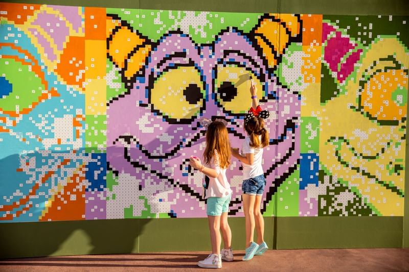 Two girls drawing a mural in Epcot International Festival of the Arts near Lake Buena Vista Resort Village & Spa