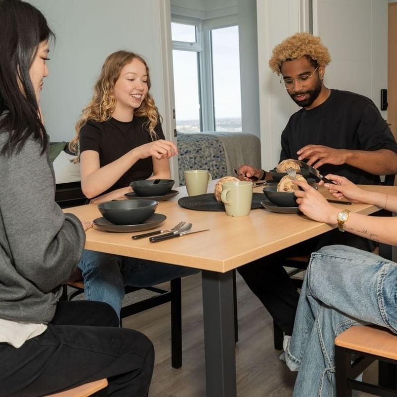 Students sit at modern and sleek kitchen table in a 4-bedroom shared apartment