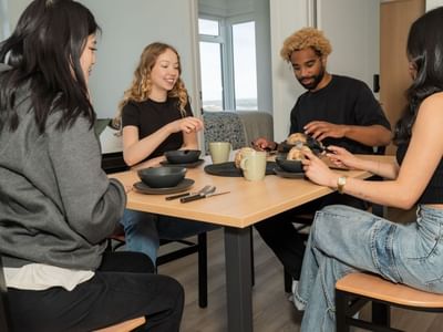 Students sit at modern and sleek kitchen table in a 4-bedroom shared apartment