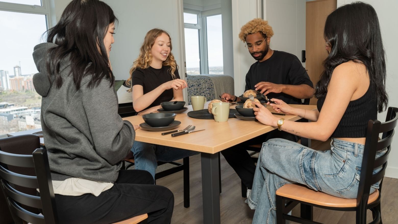 Students sit at modern and sleek kitchen table in a 4-bedroom shared apartment