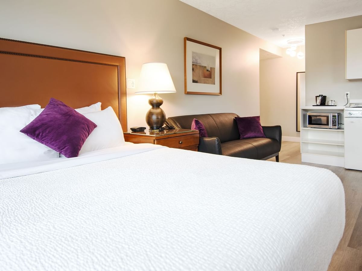 A hotel studio suite with queen bed and kitchenette