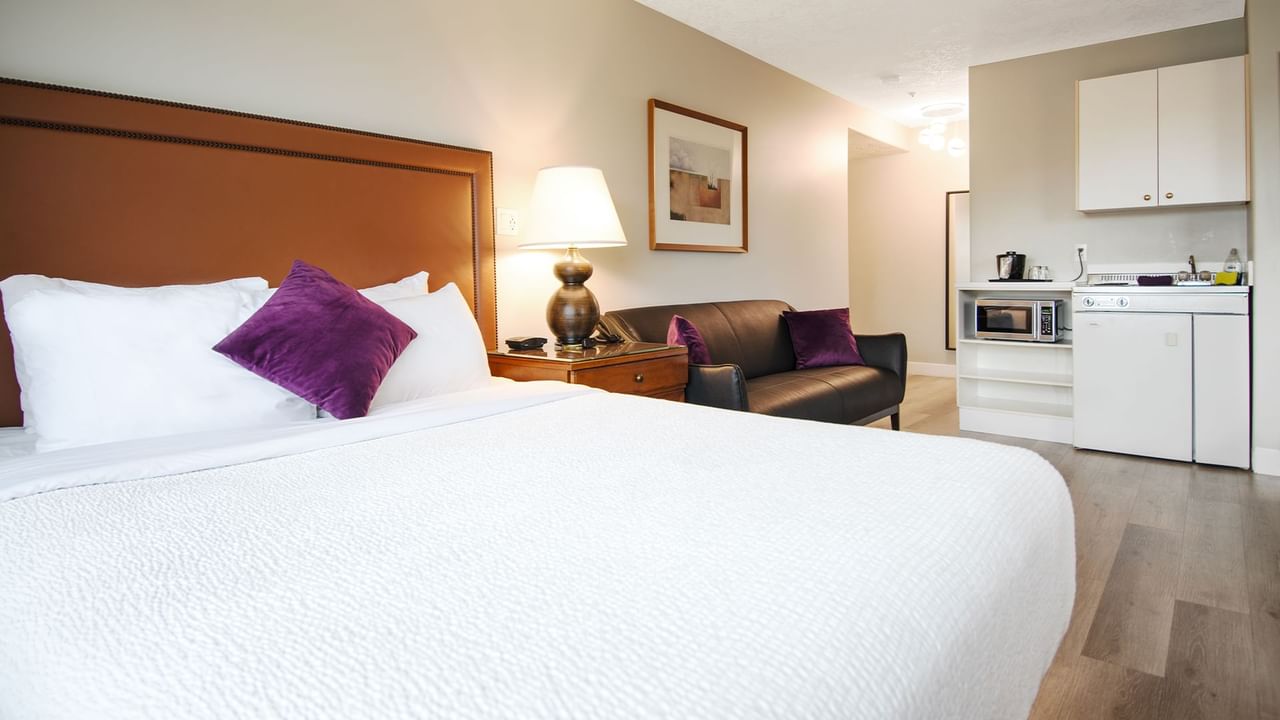 A hotel studio suite with queen bed and kitchenette