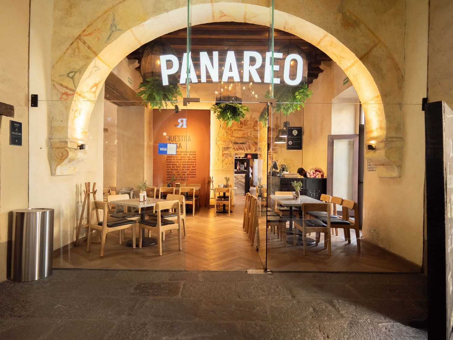 Entrance to Panareo restaurant with wooden tables and chairs at Quinta Real Puebla in Heroica Puebla de Zaragoza.