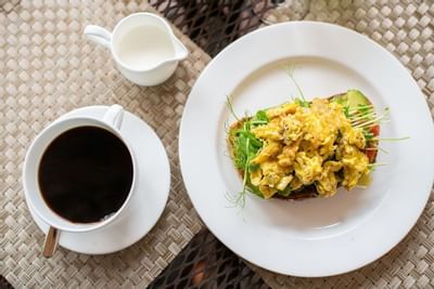 Classic breakfast of scrambled eggs on toast with coffee and cream at The Exeter Inn
