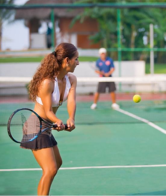 Close-up of a woman play tennis on an outdoor tennis court at Plaza Pelicanos Club Beach Resort