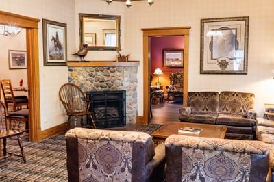 Cozy lounge area with a stone fireplace and comfortable armchairs at The Ranch at Ucross
