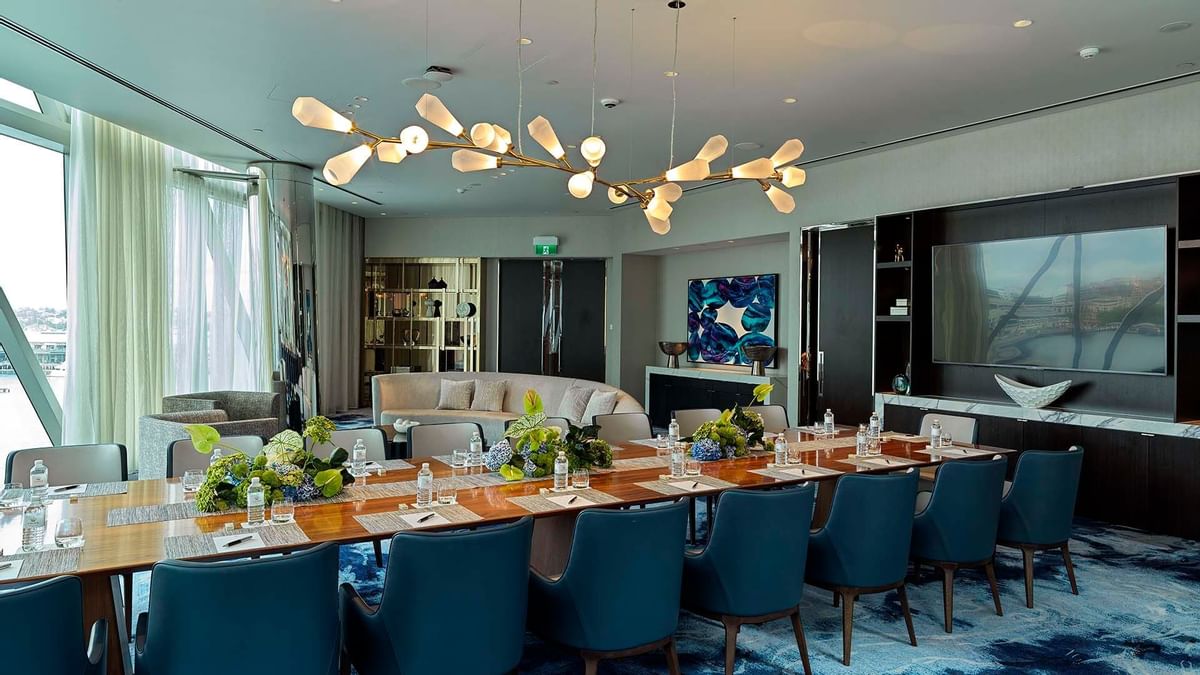 Dining area with set up tables, artistic light fixtures, and a view outside in Opal Suite at Crown Towers Sydney