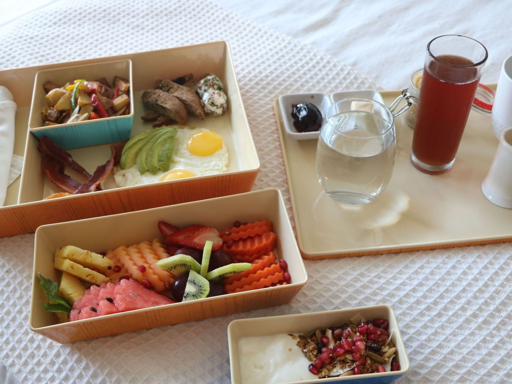 Close-up of served morning snacks on a bed at Alaia Belize Autograph Collection
