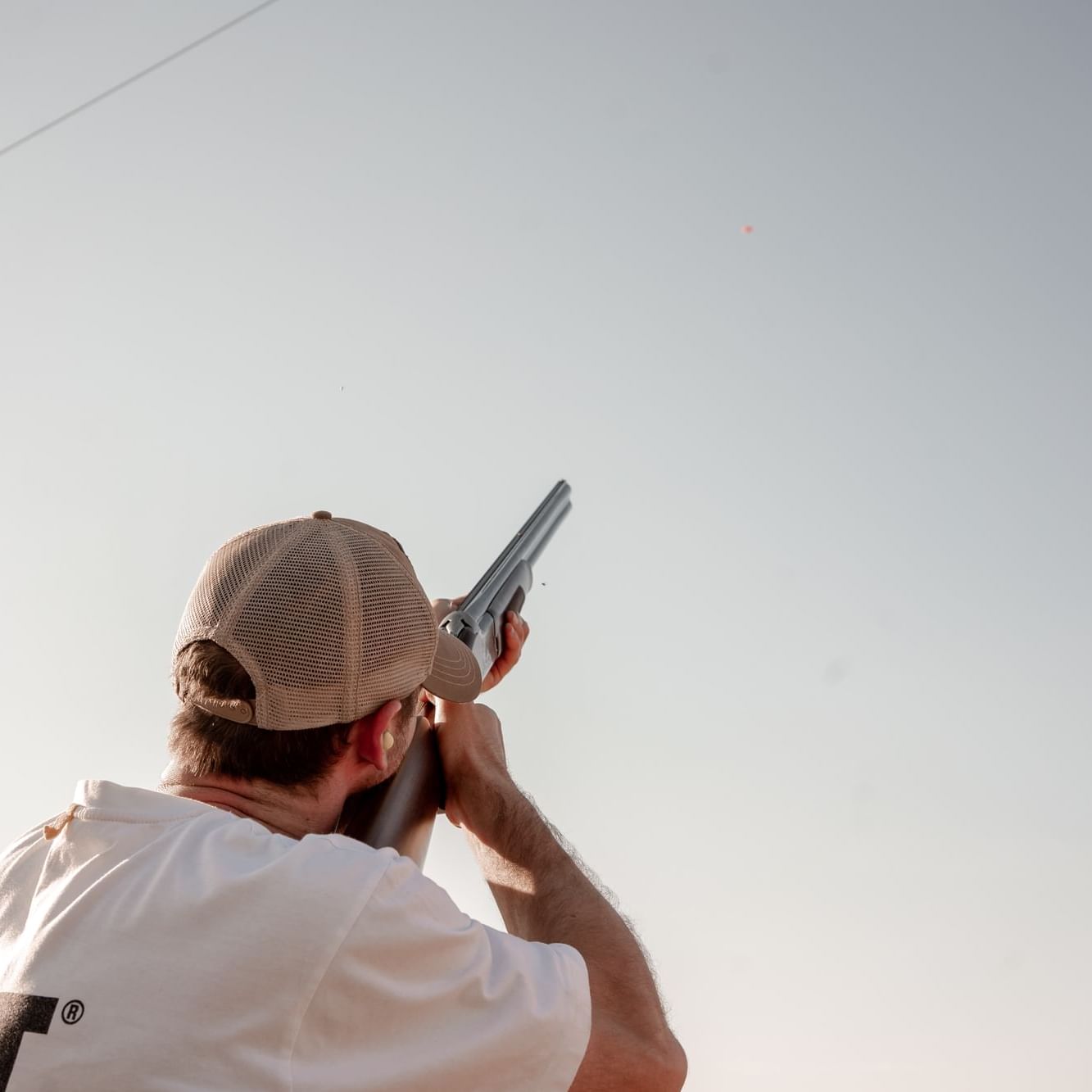 Close-up of man pointing a gun to the sky near Hotel Jackson