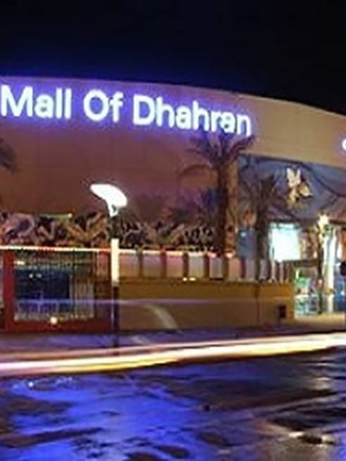 Mall of Dhahran exterior by a street under night lights featuring a large glowing sign near Warwick Al Khobar