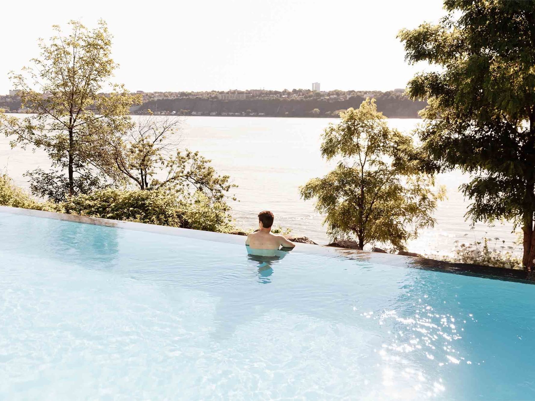 Man relaxing in the outdoor pool of Strom Spa at Hotel Port Royal